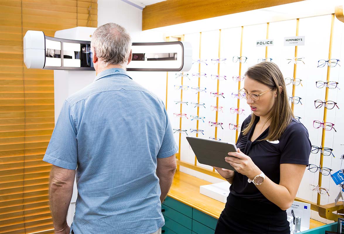 Heron Eyecare staff member checking eye health of a senior man